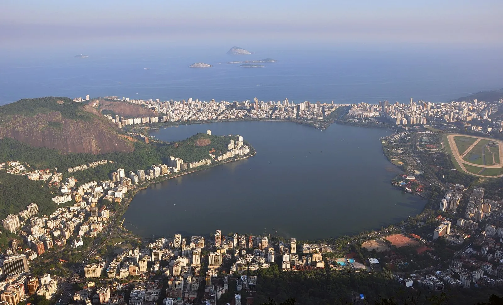 Aerial view of the Lagoa Rodrigo de Freitas lagoon ringed by South Zone apartment buildings, with Ipanema and the ocean beyond