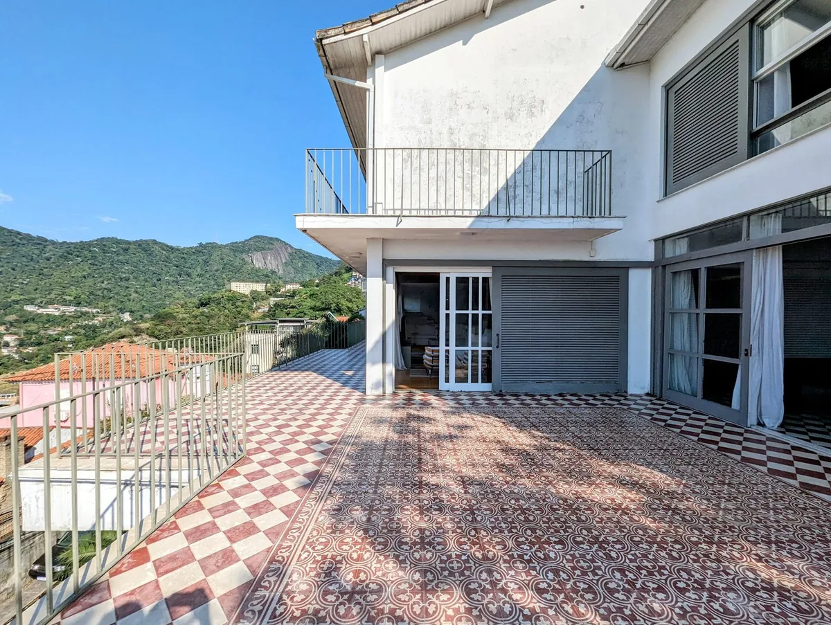 Terrace and white façade of a Santa Teresa house with patterned tiles and mountain views