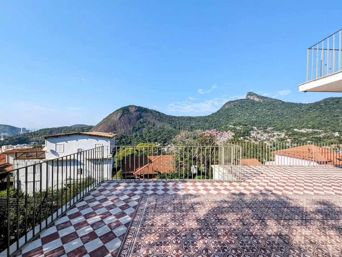Patterned-tile terrace of a Santa Teresa house with a railing and views of the city and Corcovado