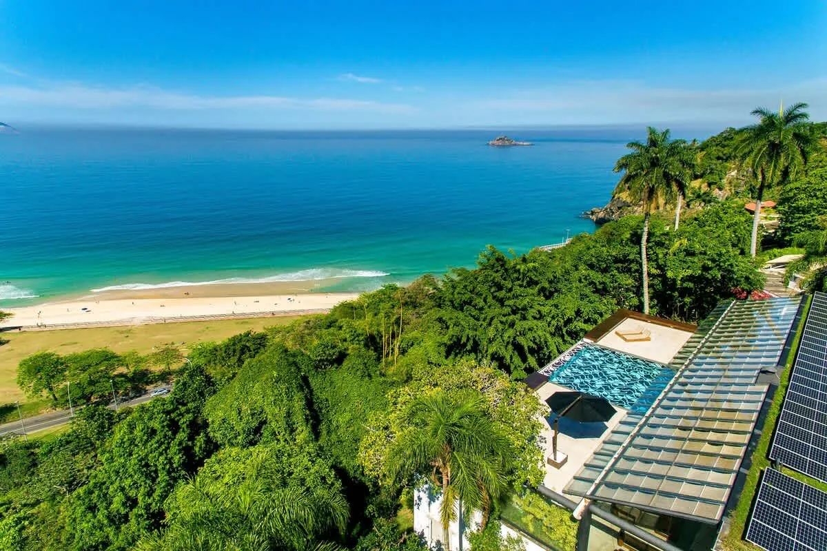 Aerial view of the São Conrado Beach View Villa among the trees with São Conrado beach and the sea below